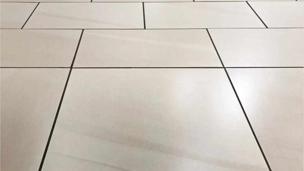 Off-white tile floor with dark grout lines, perspective view.