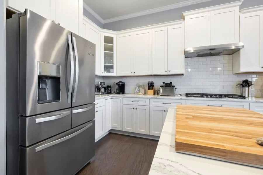 Integrated fridge built into cabinetry in a small Bath kitchen