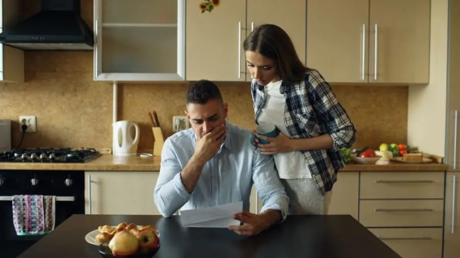 Couple checking a kitchen quote and deposit request at home in Bath