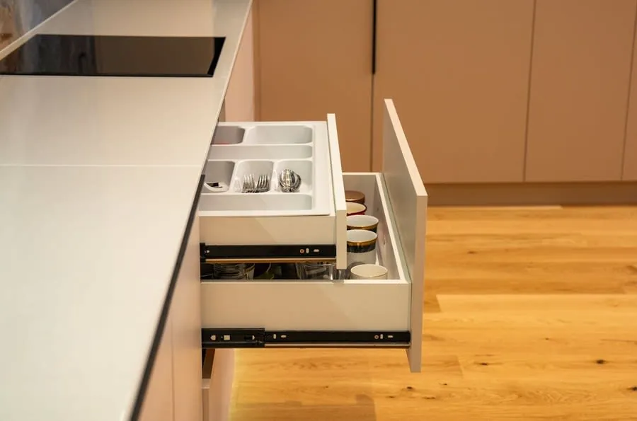 Open kitchen drawer with cutlery insert being checked for alignment in a Bath kitchen