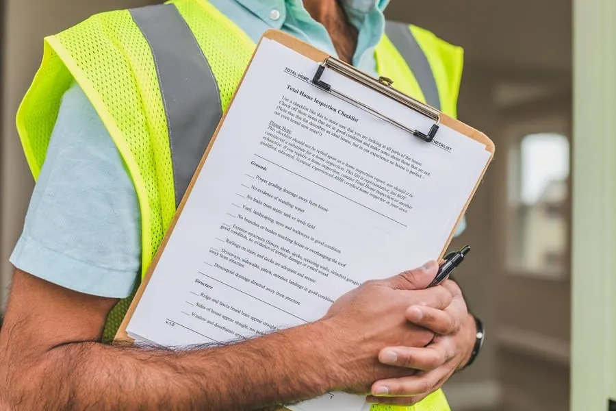 Snagging checklist on a clipboard during a kitchen installation inspection
