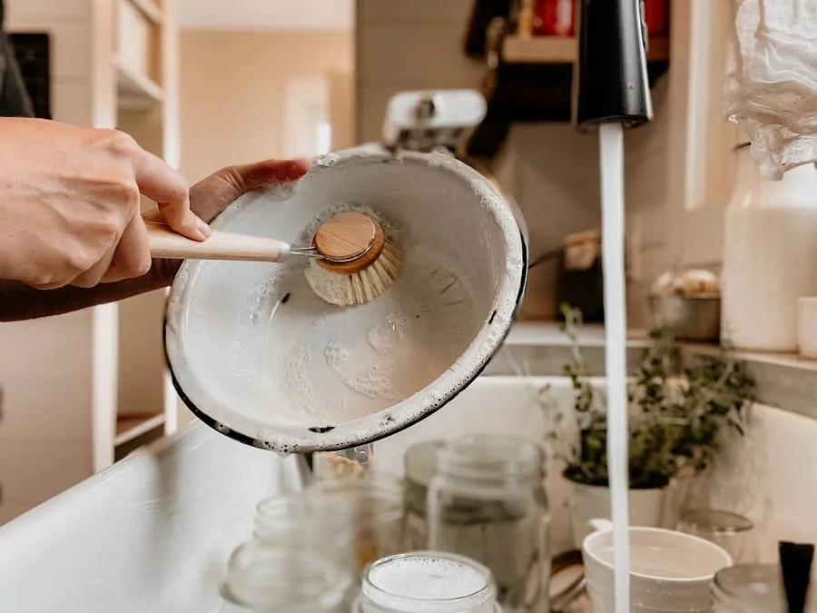 Washing up a bowl by hand during a kitchen renovation without a working kitchen sink